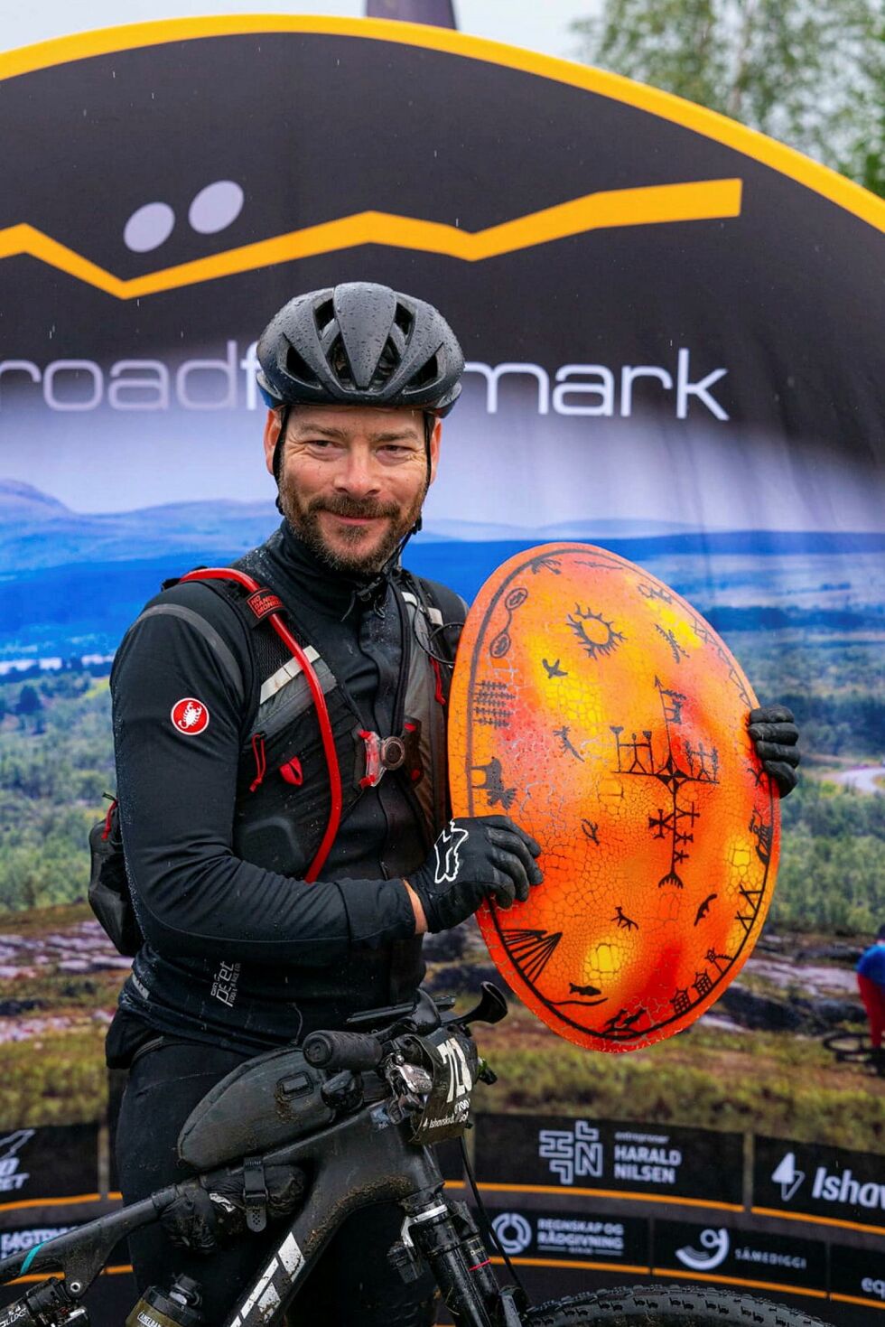 David Riiber fra Eiker CK først over målstreken i Alta i Offroad Finnmark 700 solo, menn. Det vakre symbolet på seieren er premien levert fra Arctic Glasstudio i Berlevåg.
 Foto: Marit Leinan Abrahamsen