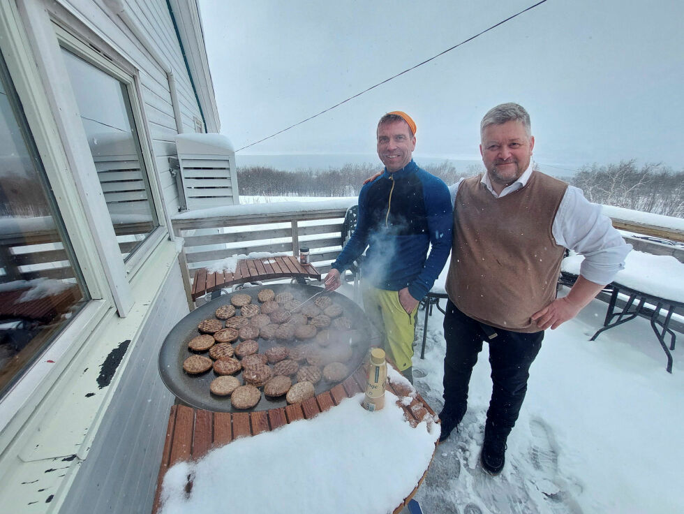 Robert Wille (t.v.) og Anders Mikkola sto for grillinga av utallige hamburgere og pølser på verandaen i det ikke altfor fine været.
 Foto: Frank Emil Trasti