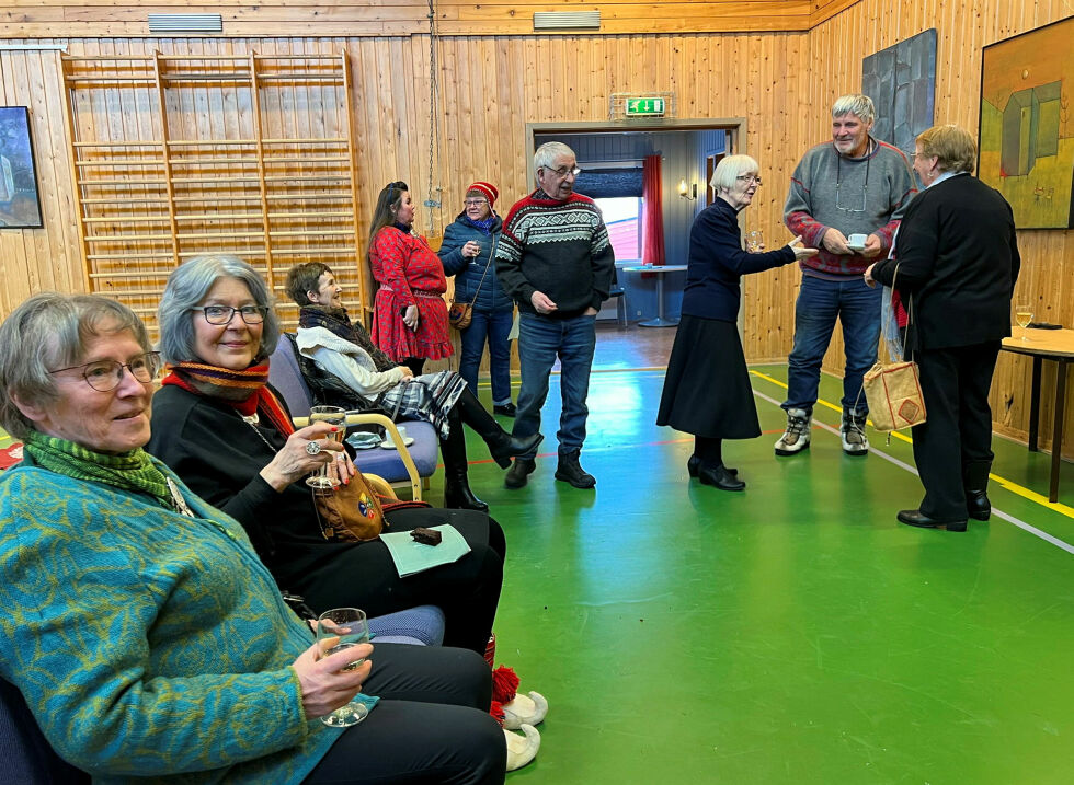 Lisas kunstnervenninner sitter og nyter bildene hennes, her Inger Haldis Ápmir og Sigrun Winterfeldt. Lisas ektemann Johannes Varsi står til venstre for henne og er meget stolt av konas kunst.
 Foto: Åsa Márgget Anti