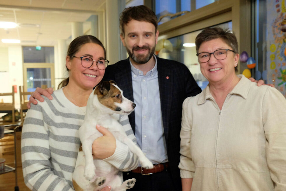 Barbro Larsen, med kosehunden Selma, helse- og omsorgsminister Jan Christian Vestre og kommunalsjef Unni Pedersen Stock på dagsenteret som er Barbros arbeidsplass.
 Foto: Bjørn Hildonen